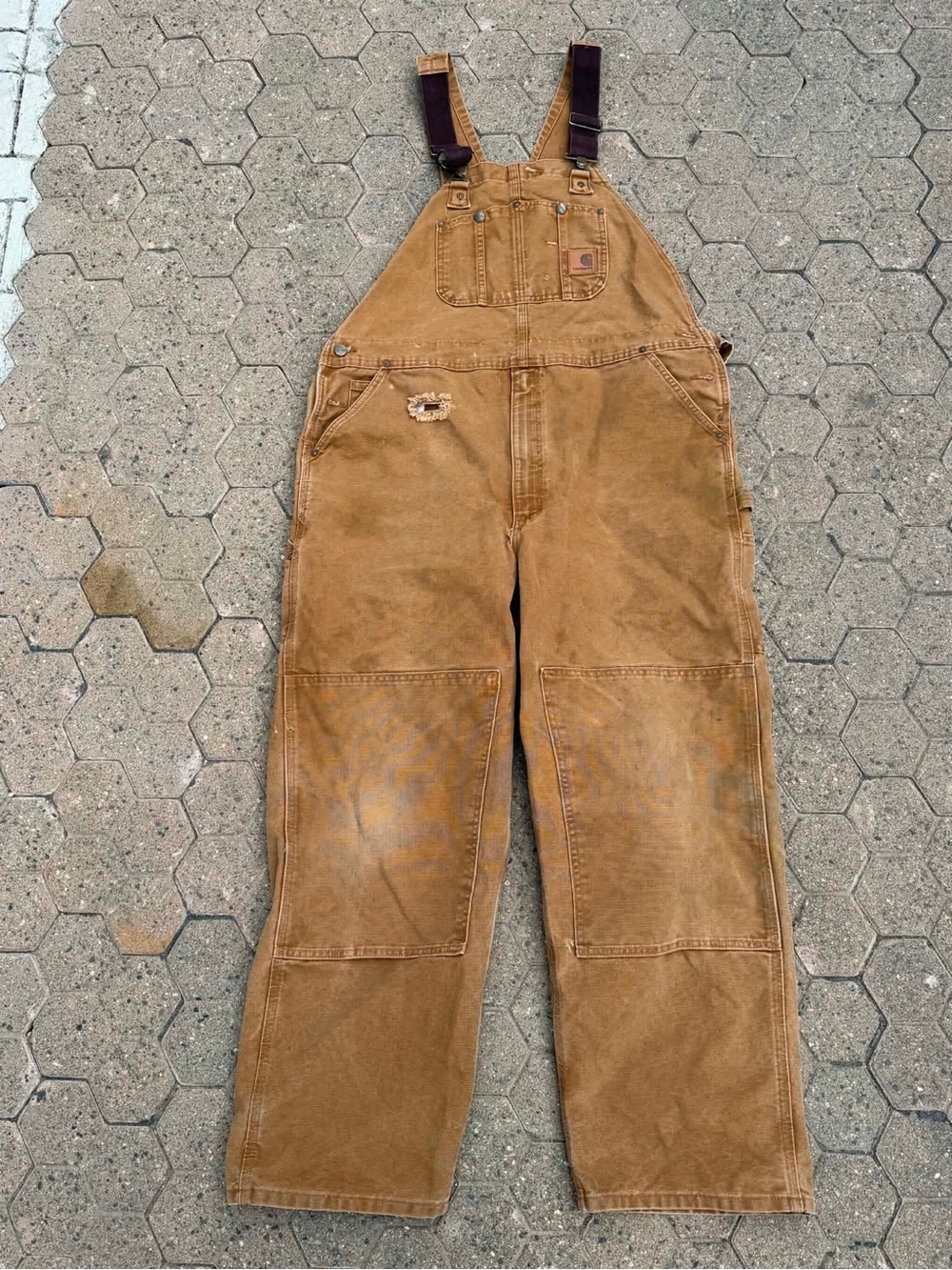 Vintage Carhartt double-knee bib overall in brown canvas featuring distressed